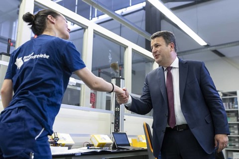 Hubertus Heil (SPD), Federal Minister of Labour and Social Affairs, greets a trainee, photographed