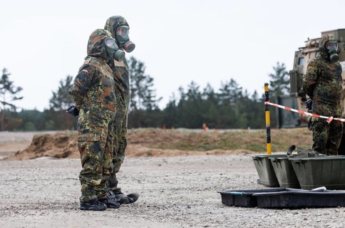 German soldiers from an NBC defence unit in protective clothing practise decontamination during the