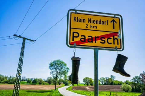Boots on town sign, farmers' protest, Paarsch, Rome, Mecklenburg-Western Pomerania, Germany, Europe