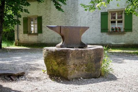 A classic anvil stands on a stone in front of a forge, Neuhausen ob Eck open-air museum, Tuttlingen