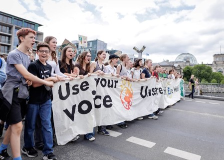 Demonstrators with signs at Fridays for Future in front of the Reichstag building, taken during the