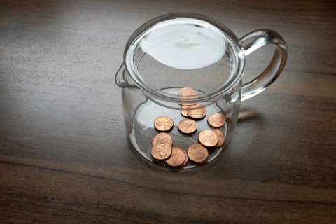 A glass container, money box, with some one cent pieces, American dollar cent, US currency, symbol