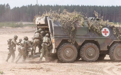 German and Dutch soldiers evacuate a simulated injured comrade as part of the NATO large-scale