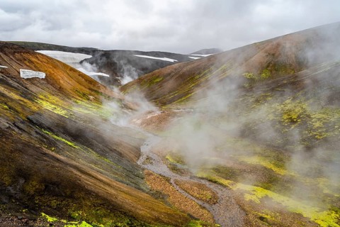 Colourful volcanic landscape with hills and snow, volcanic steaming hot springs, Laugavegur