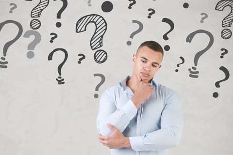 Man wondering with question marks around him