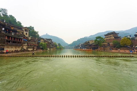Fenghuang, China, September 10, 2007: A stepping stone bridge spans the Tuojiang River which cuts