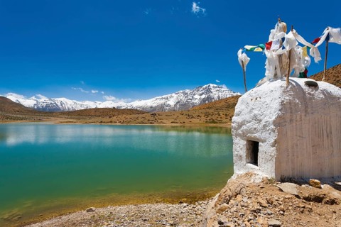 A stupa stands at the edge of a pristine mountain lake used by Buddhist pilgrims near Dhankar,