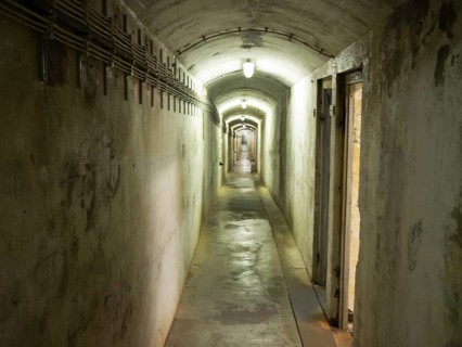 A long, closely lit tunnel with concrete walls and an oppressive atmosphere, helgoland, germany