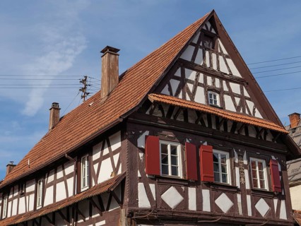 Traditional half-timbered house with red shutters under a blue sky, Kandel, Palatinate, Germany,