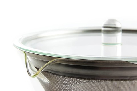 A teapot with a large tea strainer against a white background