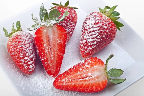 Handful of strawberries with icing sugar