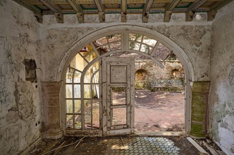 Abandoned building with arched doorway overlooking a dilapidated courtyard, Mussolini Villa, Villa