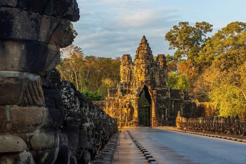 Stone Gate of Angkor Thom in Cambodia illuminated by the setting sun