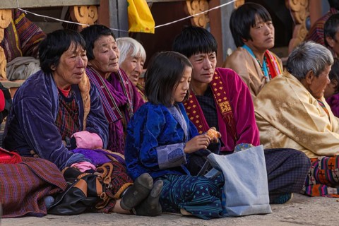 Bhutanese people in traditional clothes watching the annual Tsechu of Trongsa Dzong, Bhutan, Asia