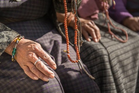 Close-up of old woman's hands with prayer beads