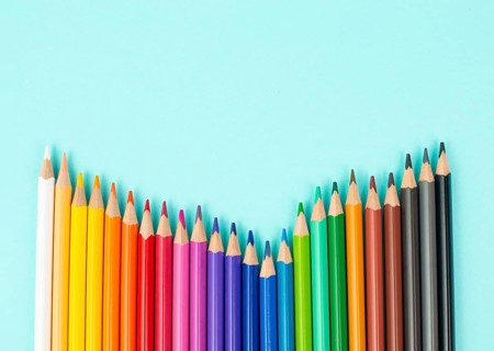 Color pencils collection in a row, back to school, drawing supplies, blue background with copy