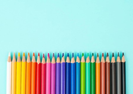 Color pencils collection in a row, back to school, drawing supplies, blue background with copy