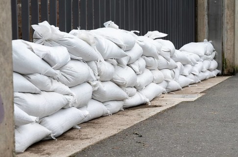 Sandbags for flood defense, river Moselle Trier in Rhineland Palatinate, flooded trees and paths,