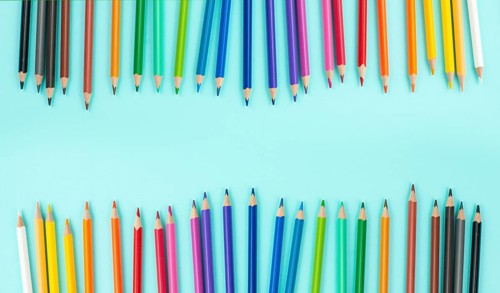 Color pencils collection in a row, back to school, drawing supplies, blue background with copy