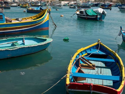 View of several colourful boats floating on the water in the harbour, marsaxlokk, mediterranean