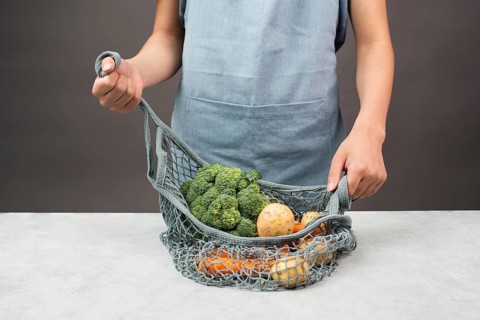 Mesh bag with vegetables, shopping grocery, healthy food ingredients, potato, broccoli and carrots,