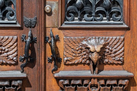 Detail, entrance door with gecko door handles and wood carvings in the shape of birds, Vasaplatsen,