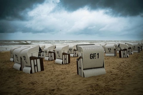 Roofed wicker beach chairs at the baltic sea beach, coast at the island of Usedom in Germany, storm