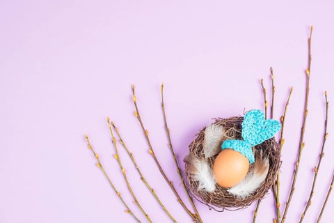 Easter bunny or rabbit in a bird nest, made from an egg and crocheted ears, spring holiday,