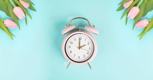 Alarm clock with tulips, switch to daylight saving time in spring, summer time changeover