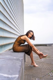 Portrait of an attractive middle eastern woman in the city. Fashion and glamor concept, sitting