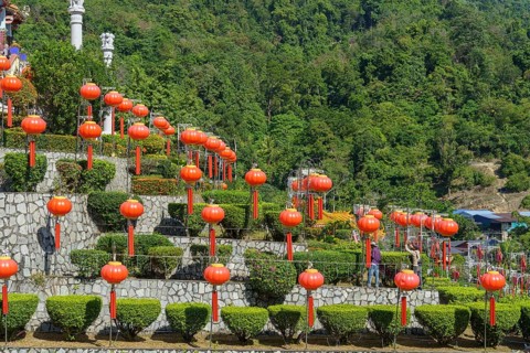 Stairs decorated with many lanterns and plants in the background of green mountains, Pattaya,