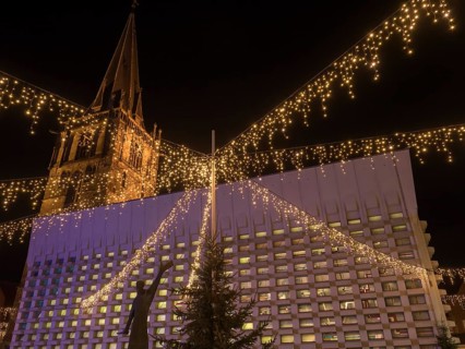 Christmas illumination with twinkling lights and tower in the background at night, Ahaus,