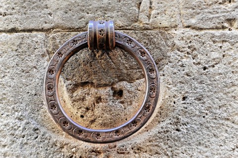 Volterra, Tuscany, Italy, Europe, Close-up of an antique metal door knocker on a stone wall, Europe