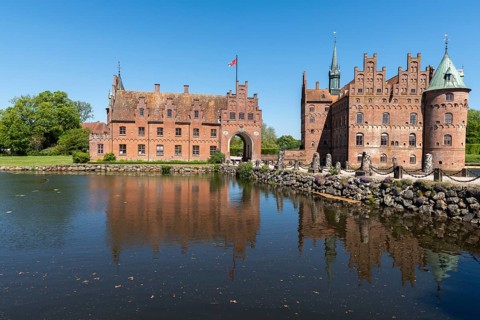 Egeskov moated castle with gatehouse, Kvaerndrup near Svenborg, Svendburg, reflection, flag,