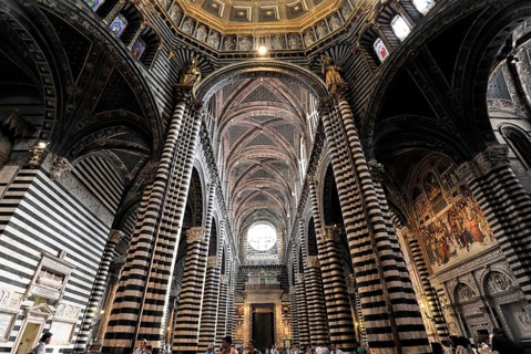 The central nave of the cathedral with its black and white striped marble columns, cross and round