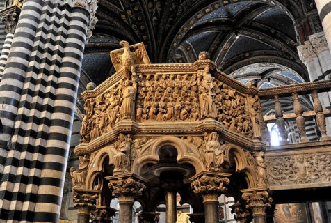 The central nave of the cathedral with its black and white striped marble columns, cross and round