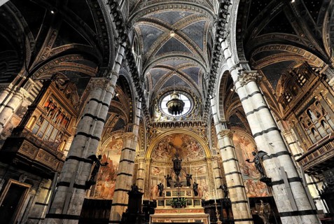 The central nave of the cathedral with its black and white striped marble columns, cross and round