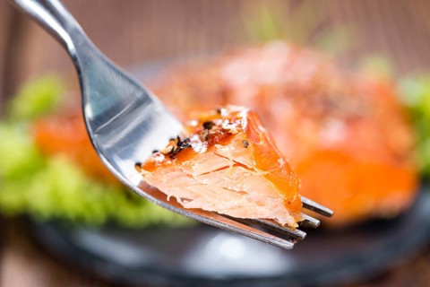 Piece of Smoked Salmon on a fork (detailed close-up shot)