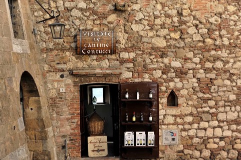 Montepulciano, Tuscany, Italy, Europe, Rustic wine cellar with a stone wall and wine bottles,