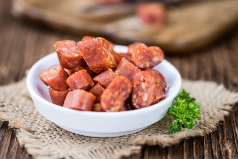 Chilli flavoured Sausages (German Mettwurst) on wooden background (selective focus)