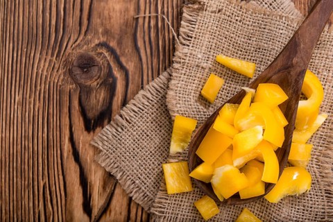 Sliced yellow Peppers (selective focus) on vintage wooden background
