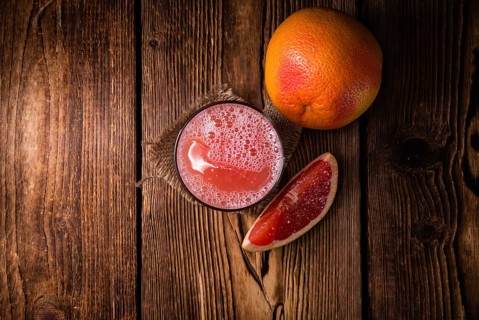 Freshly Squeezed Grapefruit Juice (close-up shot) on vintage wooden background