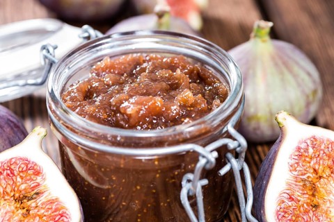 Portion of fresh homemade Fig Jam on wooden background