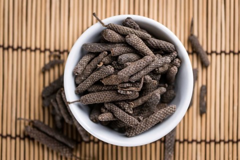 Long Pepper (dried) on an old wooden table (selective focus)