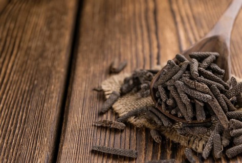 Long Pepper (dried) on an old wooden table (selective focus)