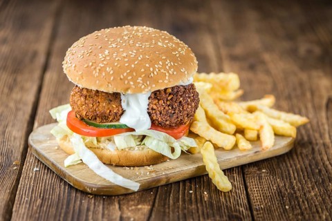 Fresh madeFalafel Burger on wooden background (close-up shot, selective focus)
