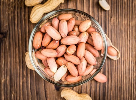Portion of Peanut Seeds on rustic background (selective focus, close-up shot)