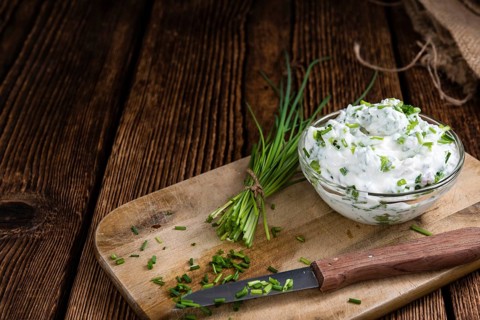 Homemade Herb Curd in bowl (close-up shot) on vintage wooden background