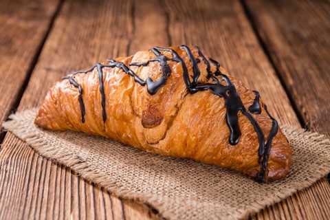 Fresh made Chocolate Croissants (close-up shot) on wooden background