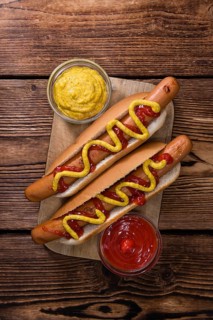 Homemade Hot Dog with ketchup and mustard on rustic wooden background